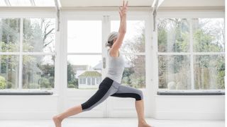 Woman demonstrating high lunge yoga position