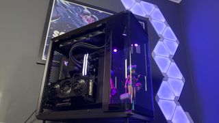The CoolerMaster MasterFrame 360 Panoramic PC case with various components installed on a desk.