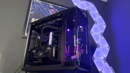 The CoolerMaster MasterFrame 360 Panoramic PC case with various components installed on a desk.