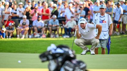  Lucas Glover reads his putt with his caddie Tom Lamb on the 18th hole green during the final round of the FedEx St. Jude Championship