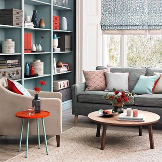 living room with grey shelves sofa set with cushion and round table