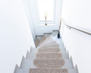 Beige stair tread with concrete style steps and white wall decor