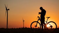 Silhouette of man on bike with sunset and camera