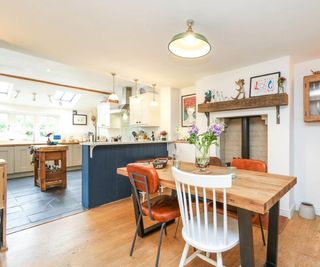 open plan kitche-diner with blue breakfast bar and oak engineered flooring