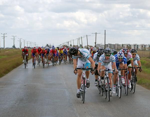 The peloton is spread across the road as riders mark each other.