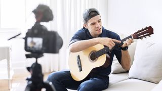 Man with acoustic guitar films a guitar vlog