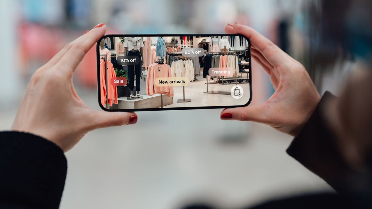 Person holds mobile phone in retail store while using AR shopping app