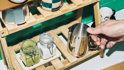 a matcha station with a hand reaching in to grab a milk jug