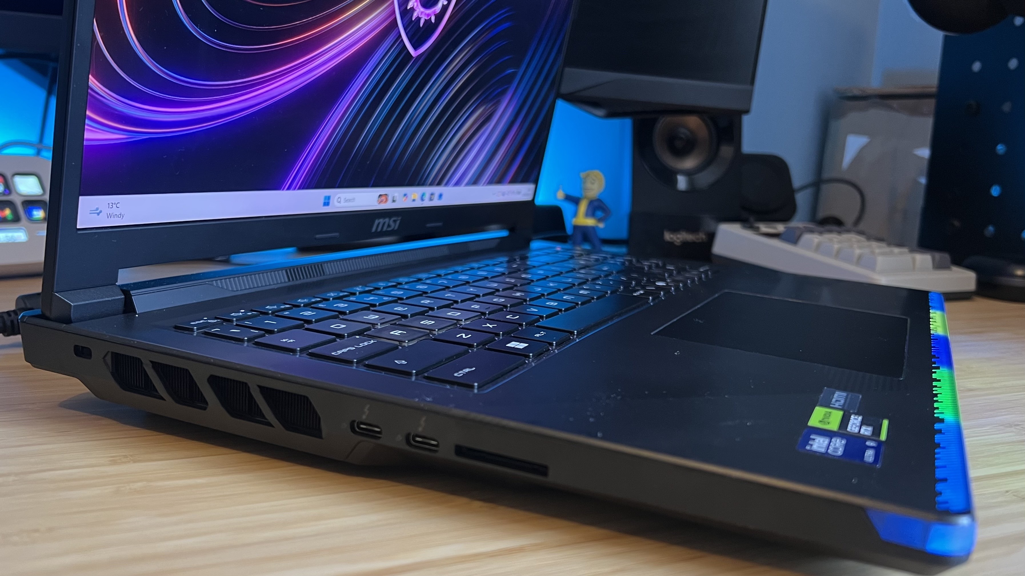 Left side view of MSI Raider 16 Max showing thickness of chassis on a wooden desk