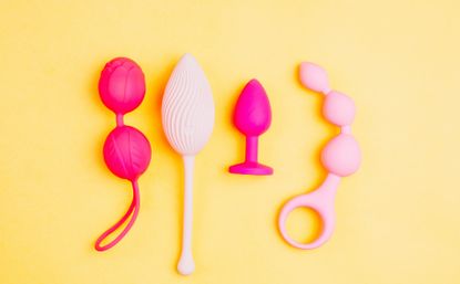 Different sex toys set on a yellow background. 