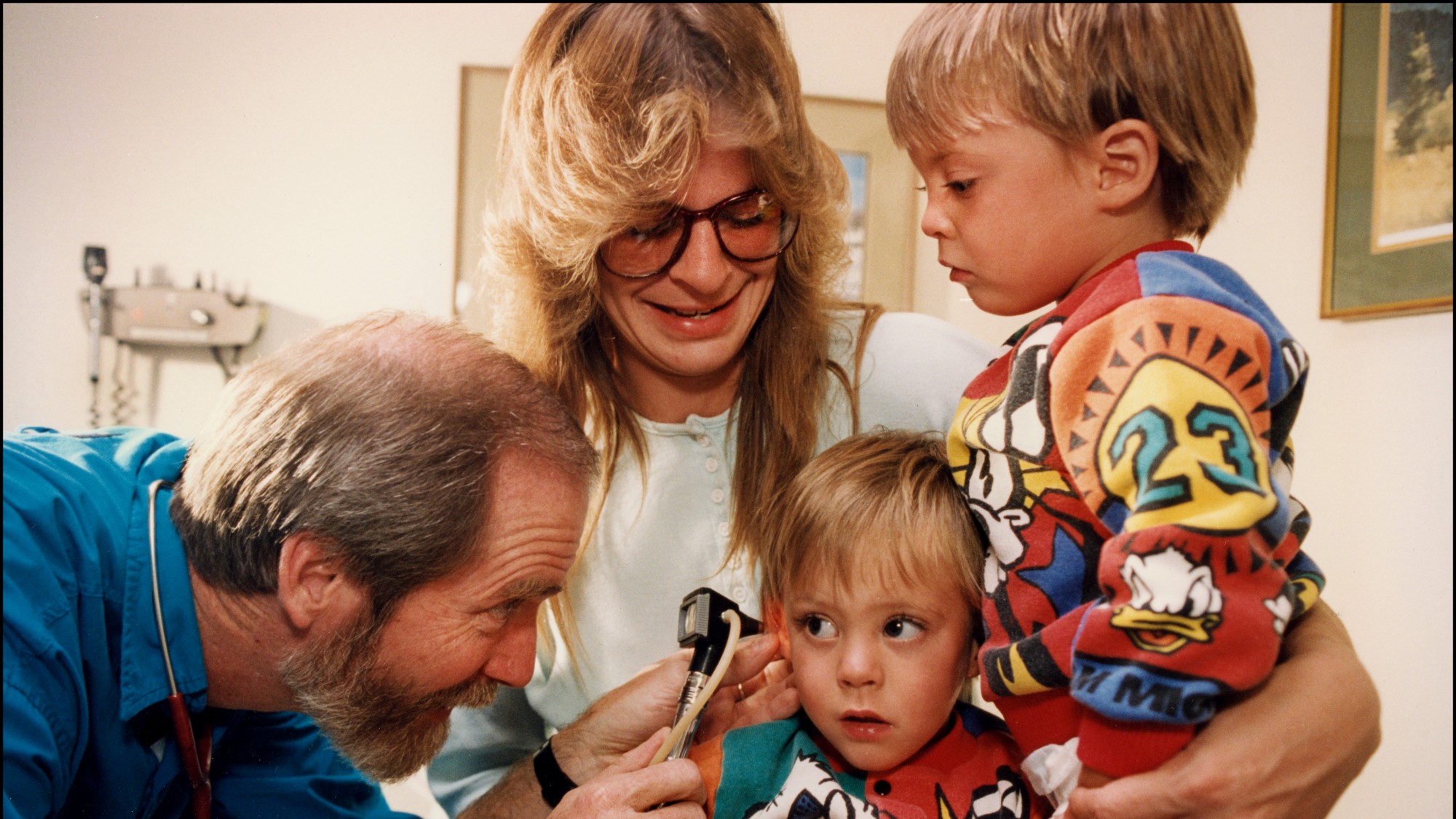View of a family doctor examining a young boy's ear