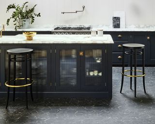 black hexagonal marble effect floor tiles in a navy kitchen with island and bar stools by Carpetright