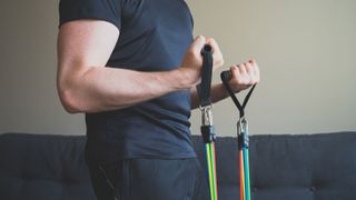 image shows man working out with resistance bands