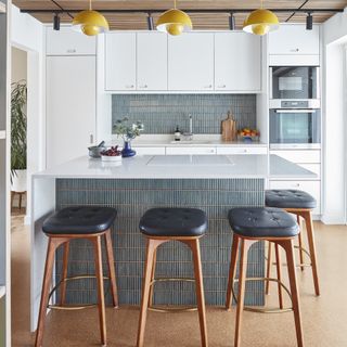 Modern kitchen with compact island with front covered in teal bamboo tiles