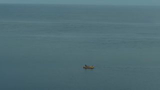 A yellow raft all alone in the ocean.