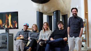 Aardman team posing in front of a Shaun the Sheep statue