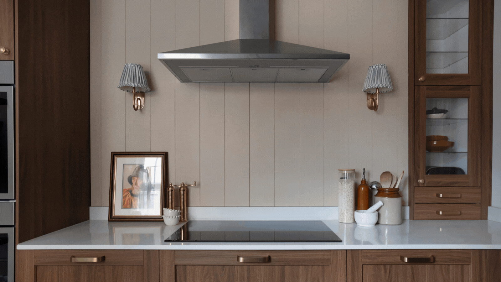 Before and after shots of a IKEA kitchen transformation - switching from light orange colored cabinets to dark wood cabinets and a clean white quartz countertops. 