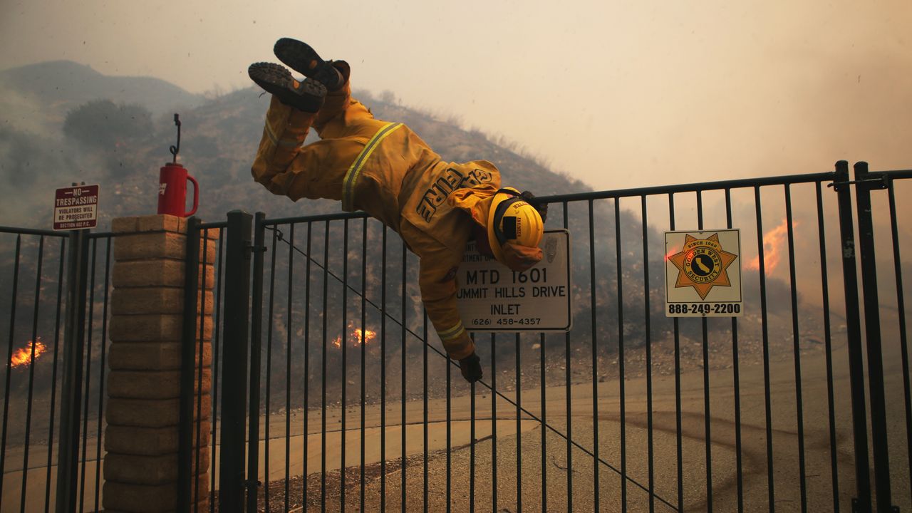 A Californian firefighter negotiates a locked gate