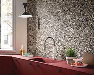 terrazzo tiles backsplash in a kitchen with matte red cabinets and brass taps - Arlo-Dark-Porcelain-Tiles