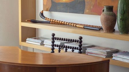 a curved desk, bobble chair and floating wall unit styled with magazines and vases