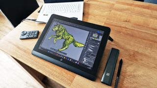 A photo of the XPPen artist pro 16 (gen 2) tablet on a wooden table with a wolf illustration on the screen