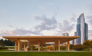 Minimalist wooden kiosk in front of the city