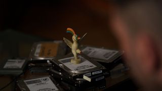 A shot of a Curro figurine standing on some hard drives from the Netflix thriller "1992"