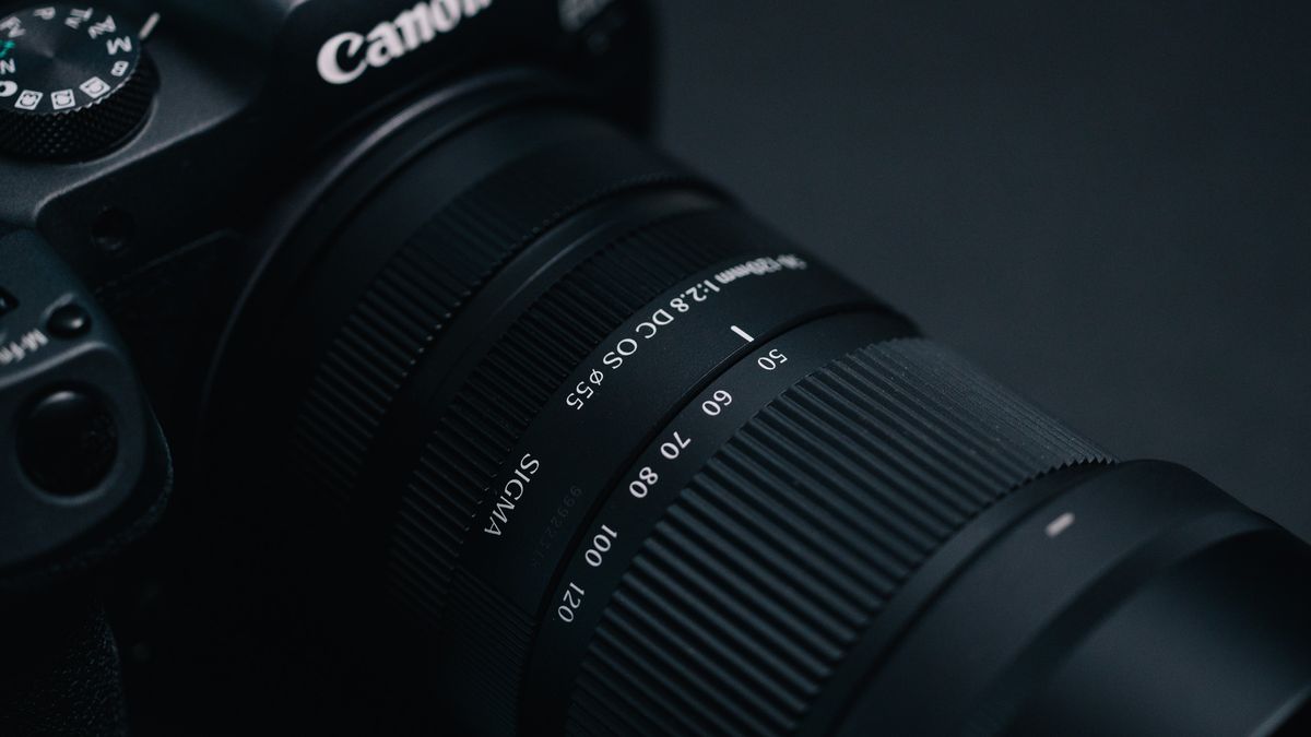 Sigma 50-120mm F2.8 DC OS Contemporary lens attached to a Canon EOS R7, in a lowkey lit studio with dark background