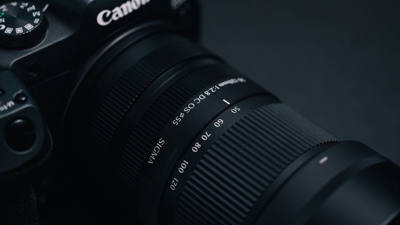 Sigma 50-120mm F2.8 DC OS Contemporary lens attached to a Canon EOS R7, in a lowkey lit studio with dark background