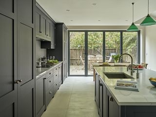 darker open plan kitchen diner with large bi fold windows by brayer design