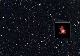 A star and and galaxy filled image with a box highlighting GN-z11, a young galaxy appearing as an irregularly shaped red "cloud" with a white center.