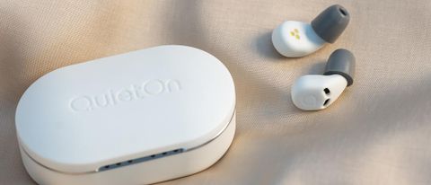 QuietOn 3 earbuds outside of case laying on tablecloth