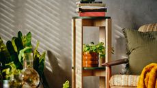 IKEA KOMPISH&Auml;NG Stacking Stools stacked as shelves with pot plants and books on them next to an armchair and potted plant