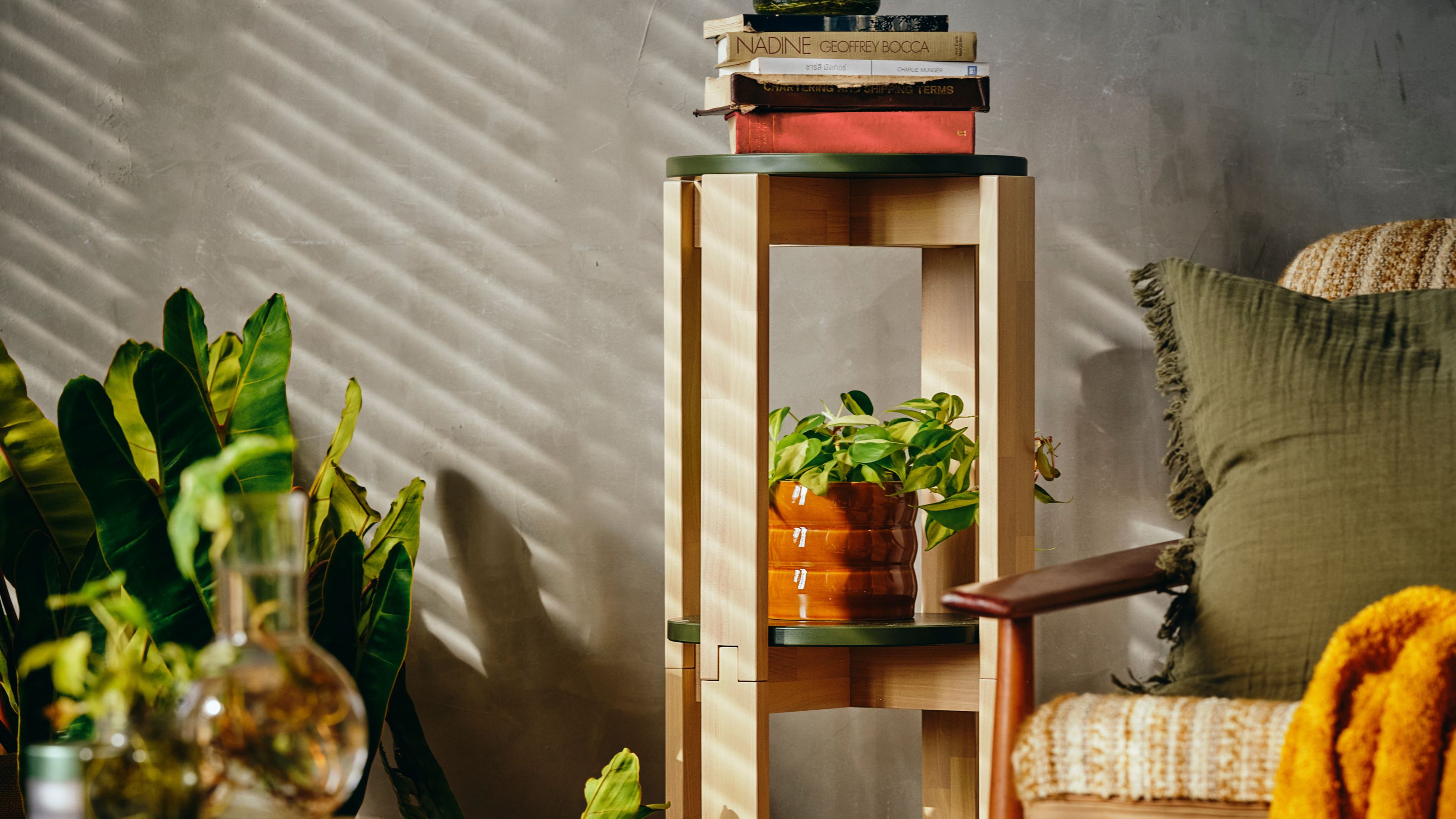 IKEA KOMPISH&Auml;NG Stacking Stools stacked as shelves with pot plants and books on them next to an armchair and potted plant