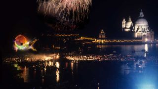 A long distance shot of Pink Floy's Venice show, with fireworks exploding above the stage