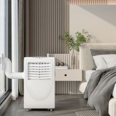 Portable air conditioner in a bedroom vented out of a large window