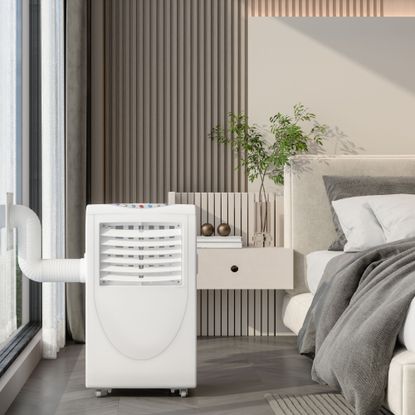 Portable air conditioner in a bedroom vented out of a large window