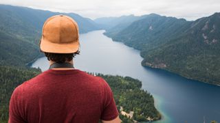 A hiker looks at lake crescent from Mount Storm King