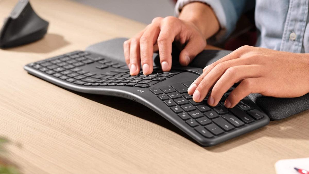 best Mac keyboard: Man typing on K860 keyboard on desk