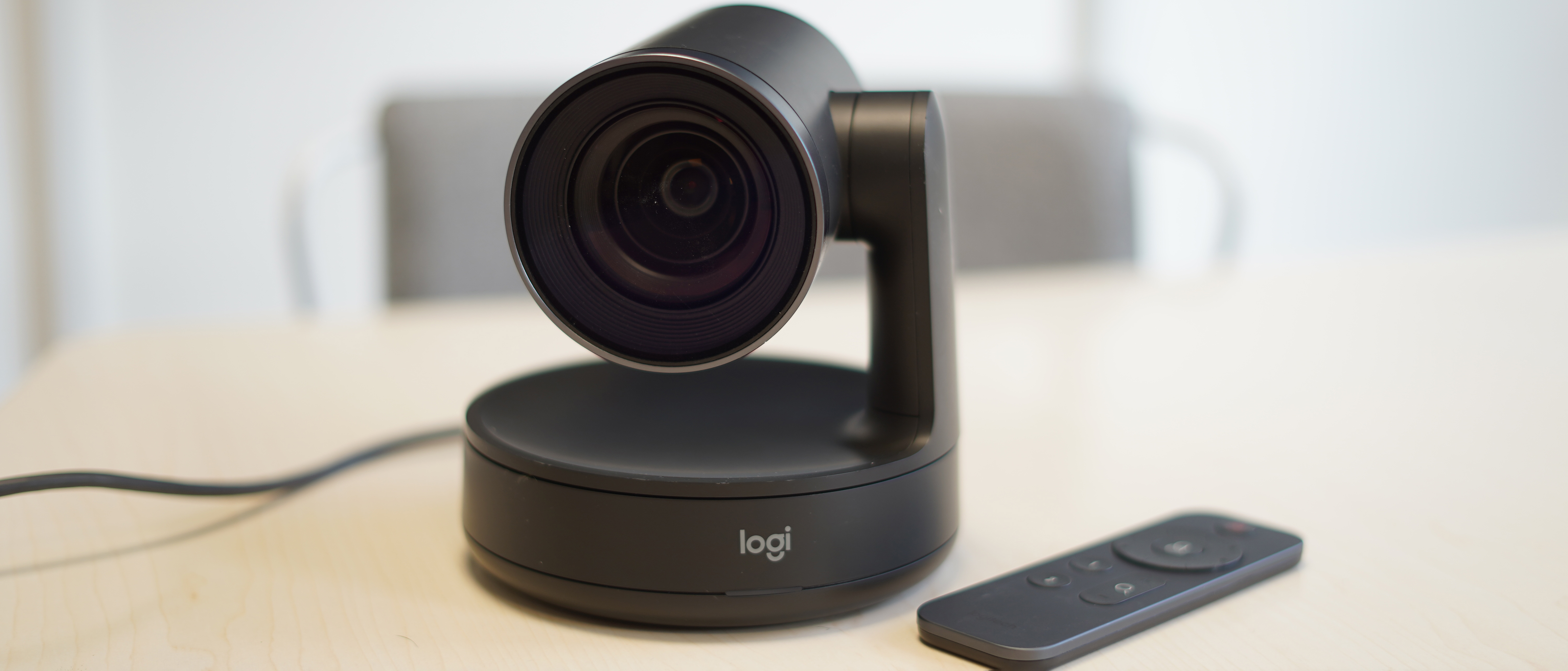 Logitech Rally camera on a table with a remote control