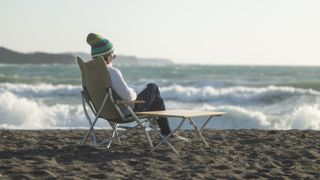 Woman sitting in camping chair with table