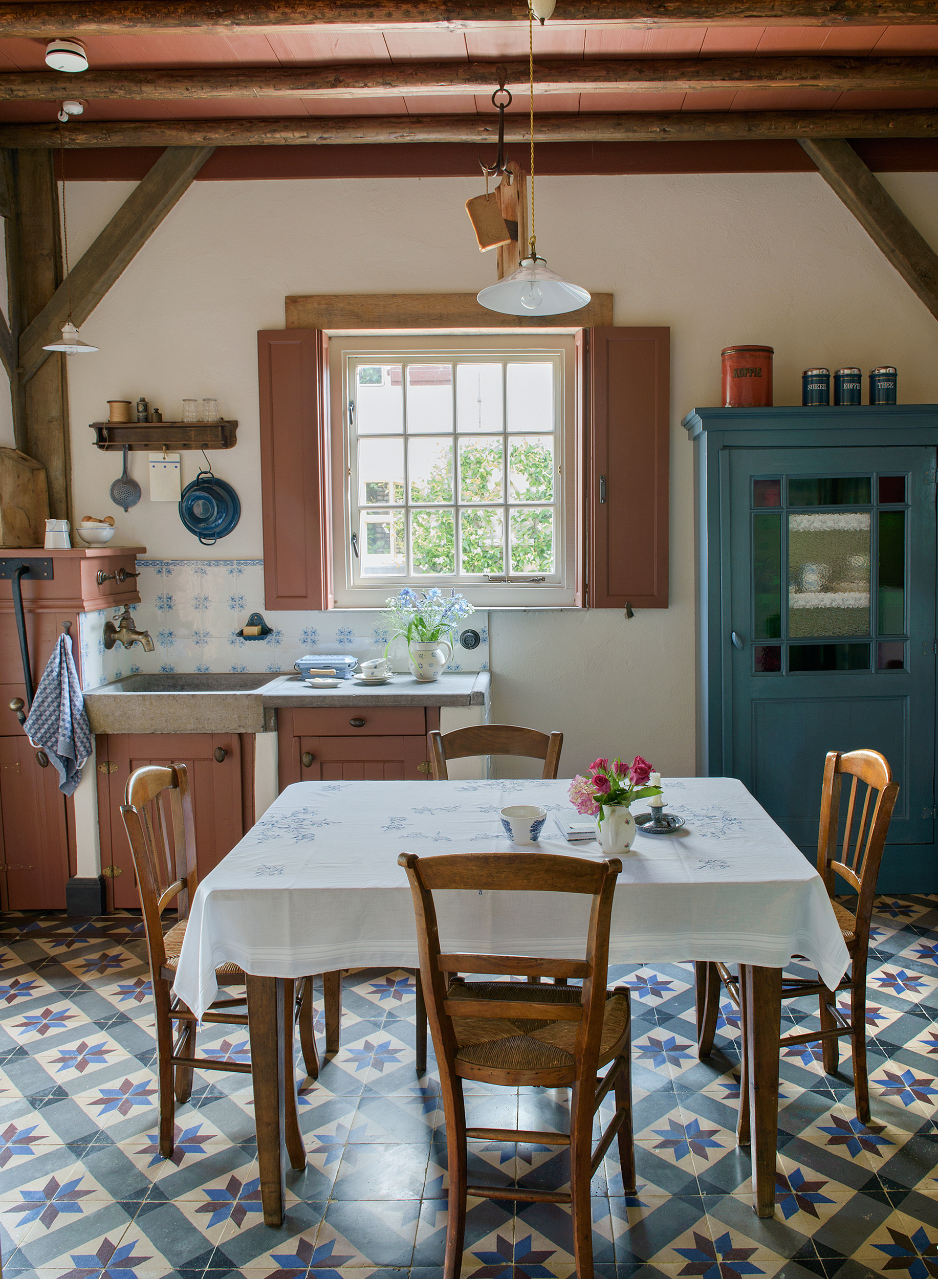 a dutch farmhouse country kitchen with blue patterned floor tiles