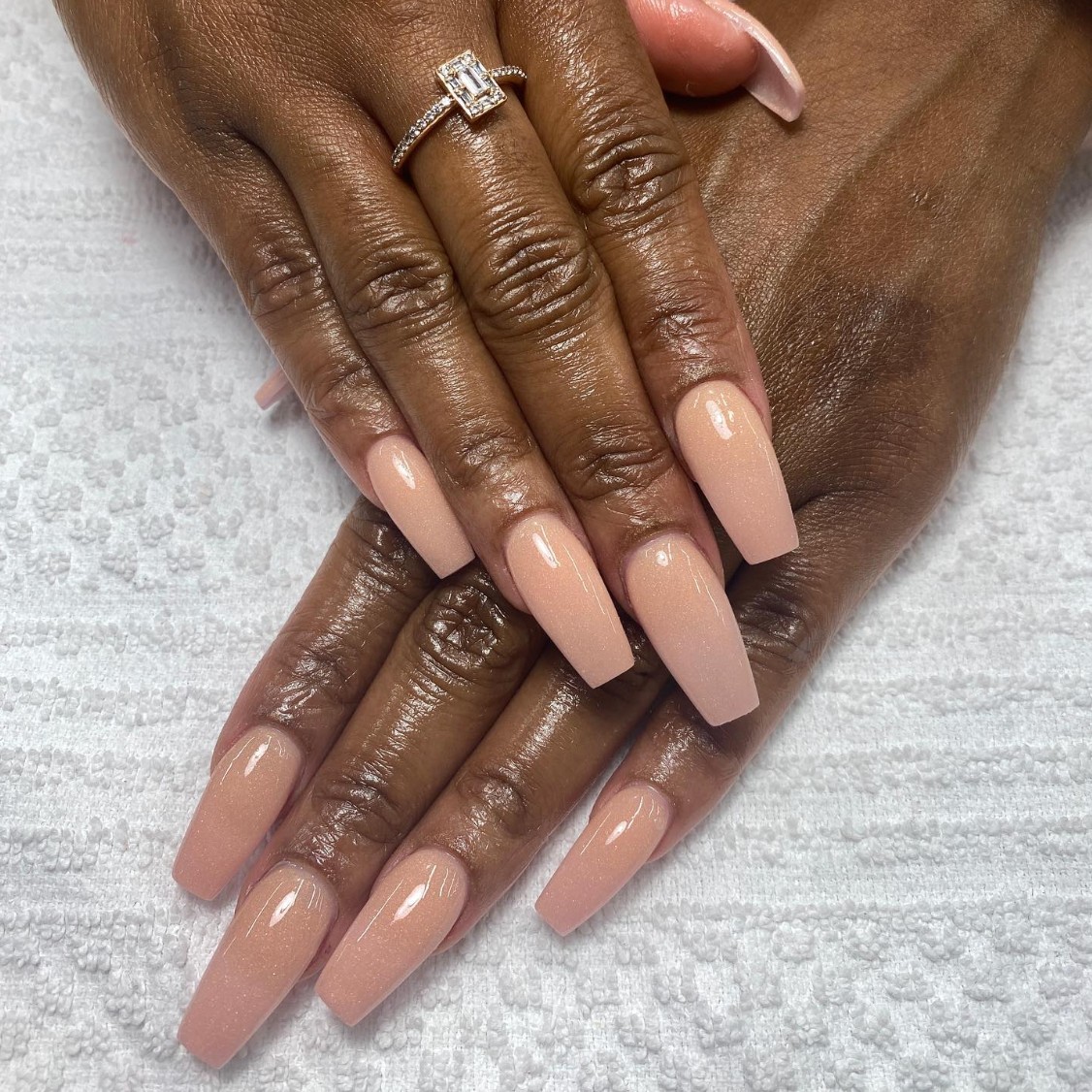 A model shows off a long, coffin-shaped nude manicure by nail artist Christina Duong.