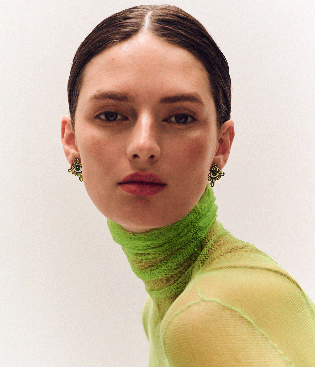 woman in green top wearing earrings