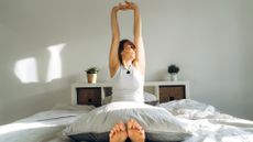 A woman stretching in bed in the morning