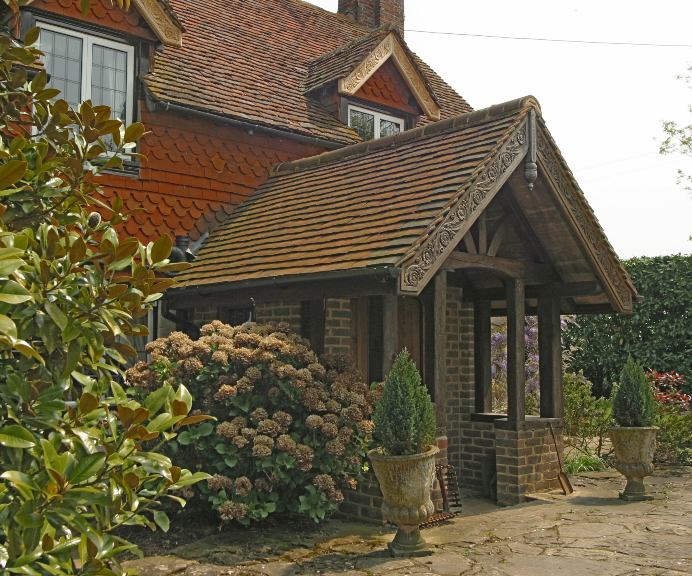 oak frame porch with tiled roof and ornate scroll design on oak fascia