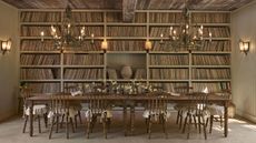 Olive Ateliers' first-ever home furnishings collection, inspired by antique French farmhouse interiors. shot inside of a high-ceilinged dining room with many books