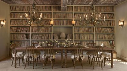 Olive Ateliers' first-ever home furnishings collection, inspired by antique French farmhouse interiors. shot inside of a high-ceilinged dining room with many books