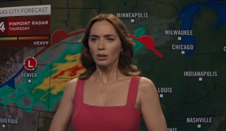 Emily Blunt reads the weather in a red dress.