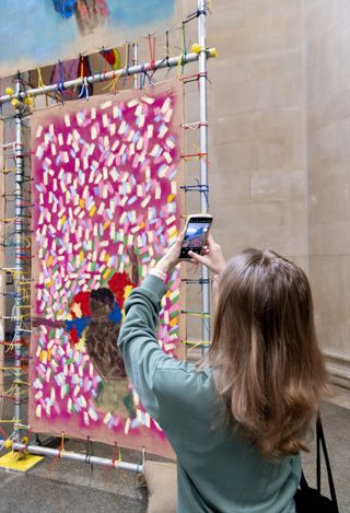 woman taking photo of red artwork